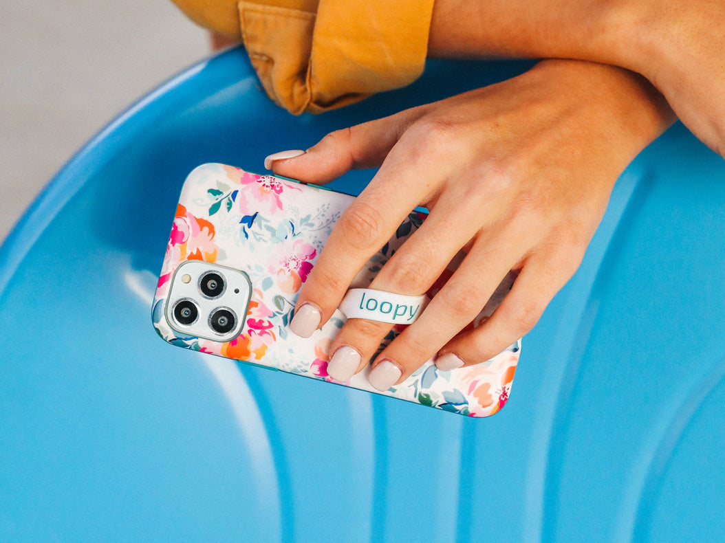 A woman holding a Gardenia Loopy Case.