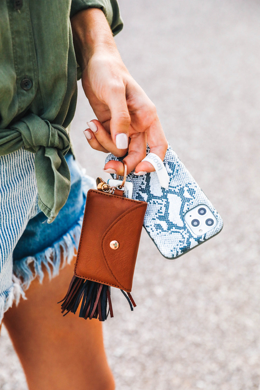 A woman holding a Snakeskin Loopy Case.