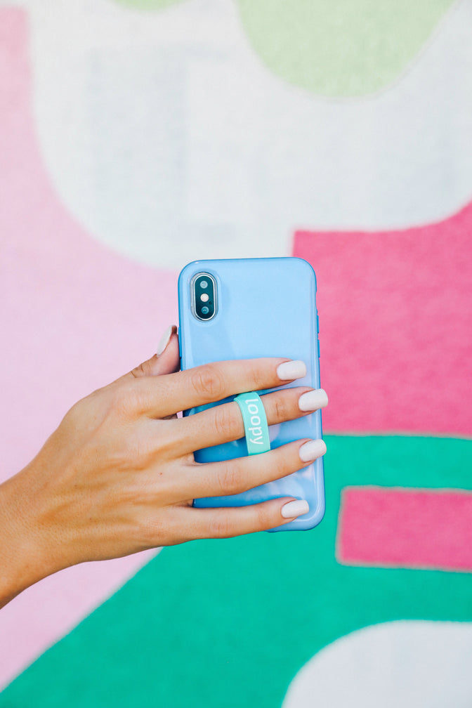 A woman holding a Periwinkle Loopy Case.