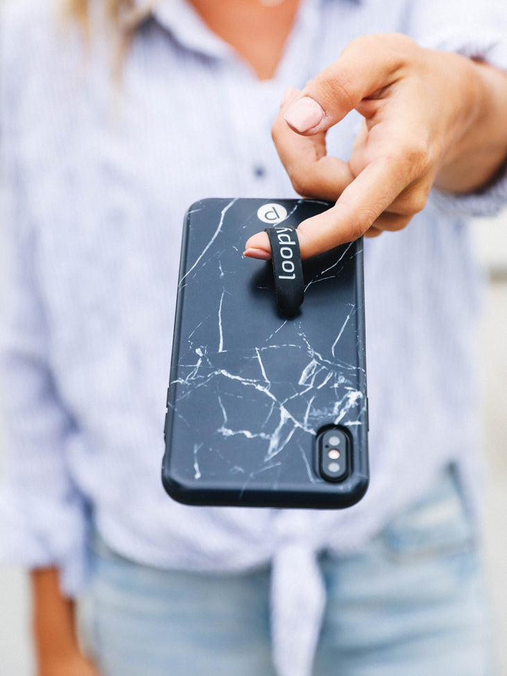 A woman holding a Black Marble Loopy Case.