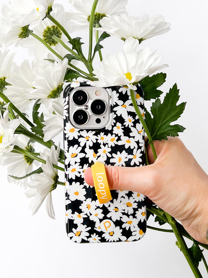 A woman holding a Daisies Loopy Case.