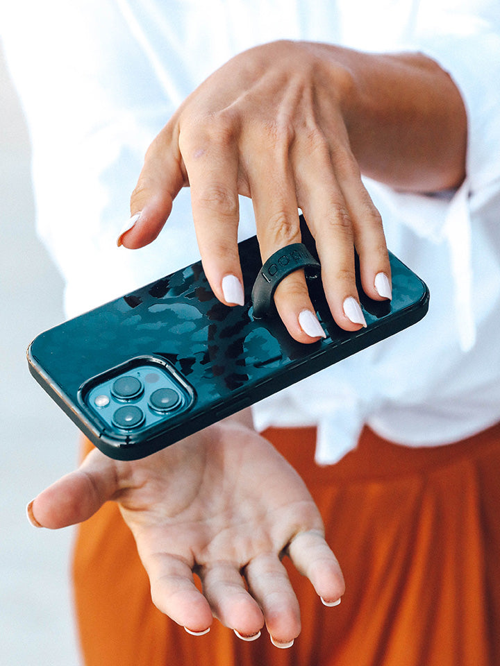 A woman holding a Midnight Leopard Loopy Case.|| feature-media