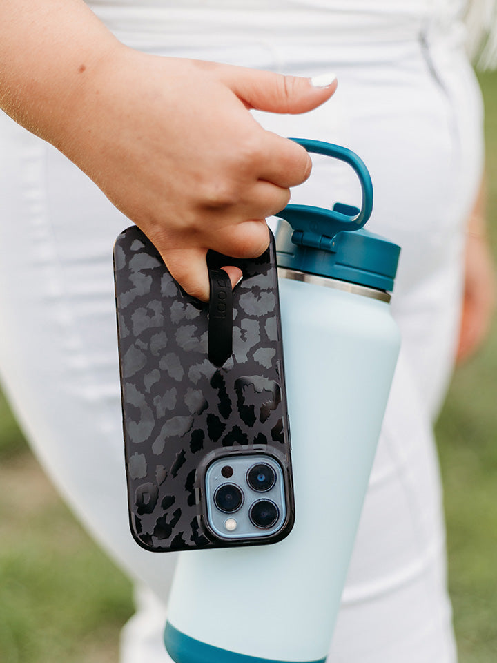 A woman holding a Midnight Leopard Loopy Case.|| feature-media