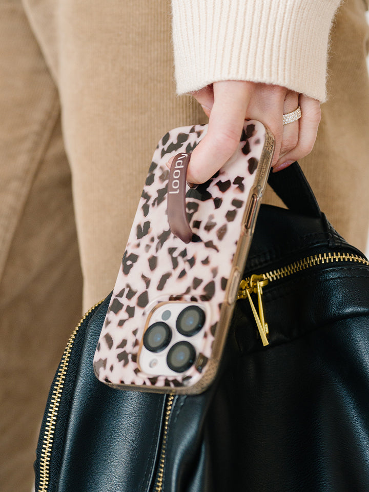 A woman holding a Blonde Tortoise Loopy Case. || feature-media