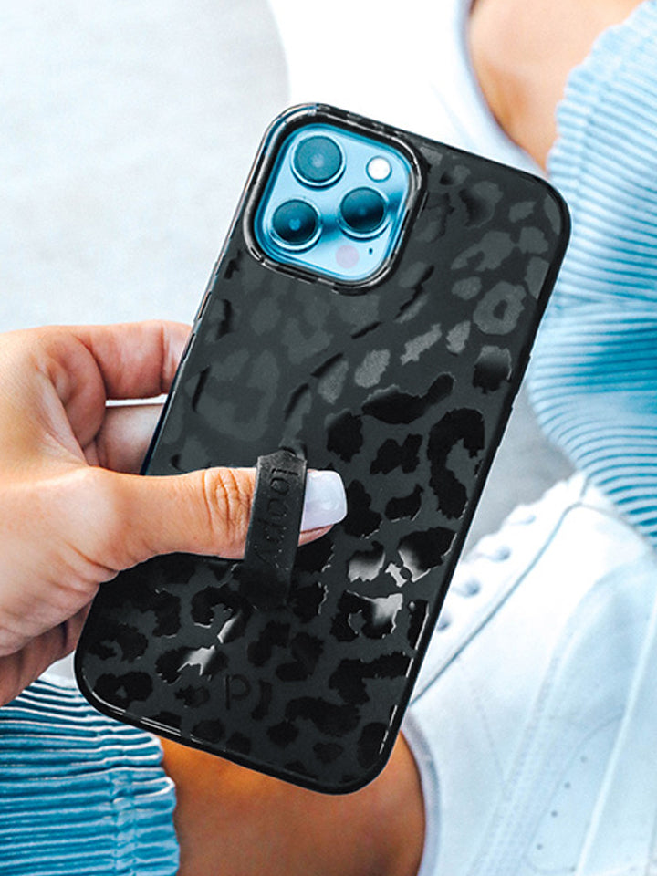 A woman holding a Midnight Leopard Loopy Case.|| feature-media