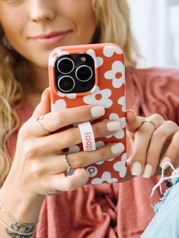 A woman holding an Auburn Daisies Loopy Case.|| feature-media