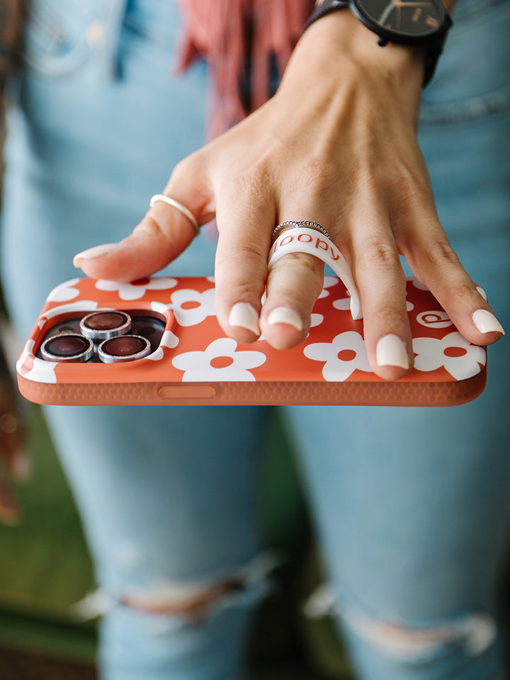 A woman holding an Auburn Daisies Loopy Case.|| feature-media