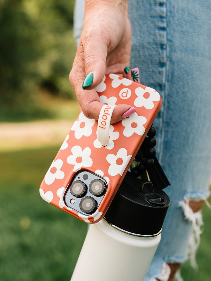 A woman holding an Auburn Daisies Loopy Case.|| feature-media