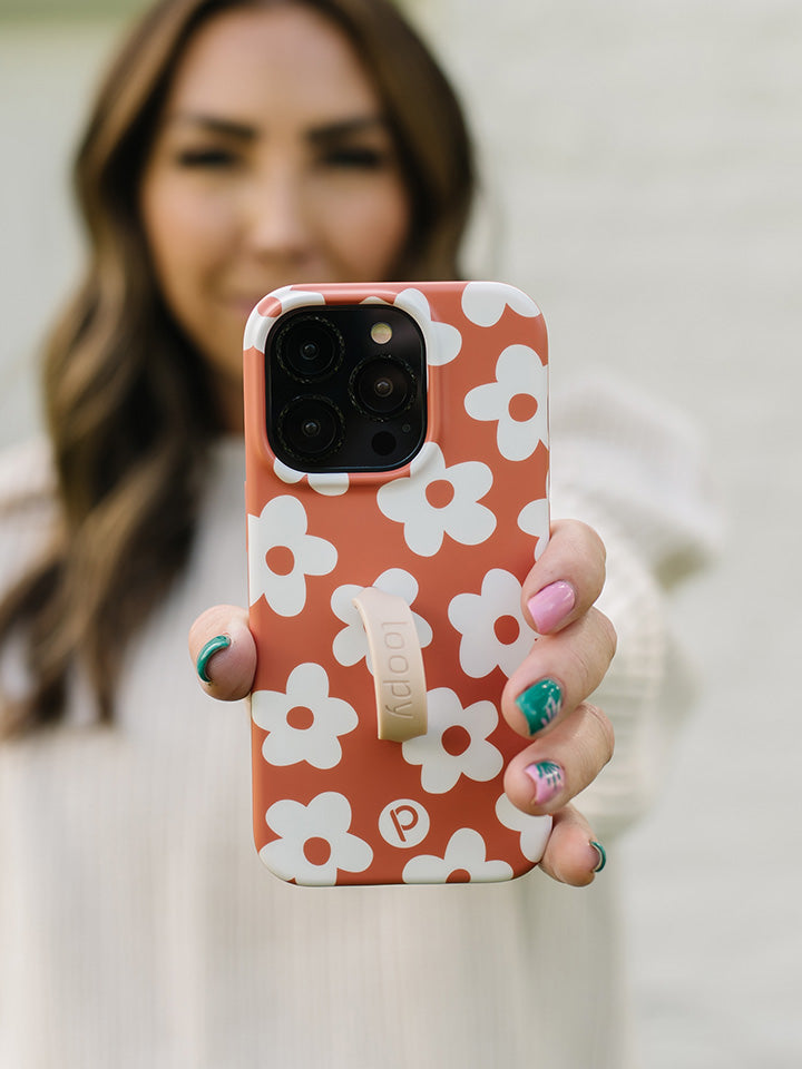 A woman holding an Auburn Daisies Loopy Case with a Sandstone Super Loop.|| feature-media