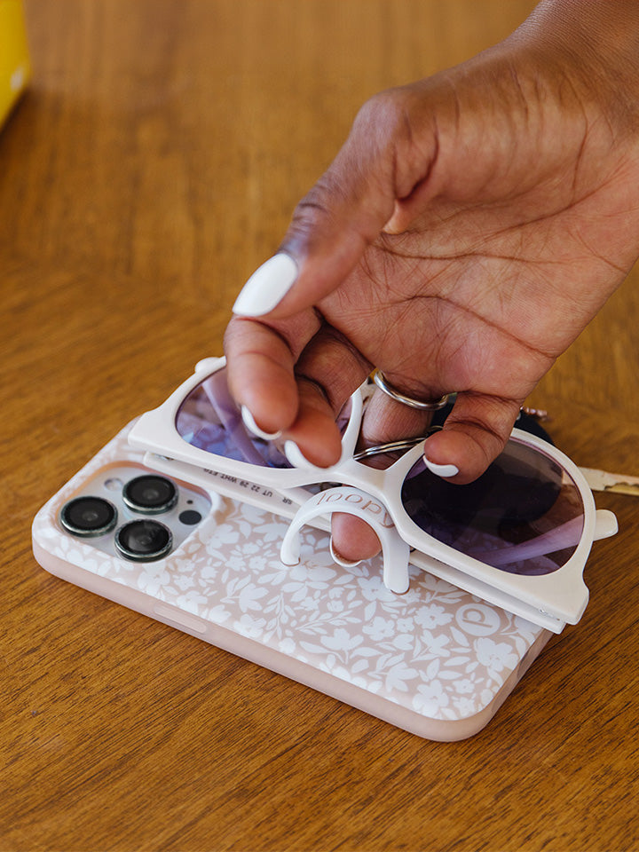  A woman holding a Beige Blossoms Loopy Case.|| feature-media