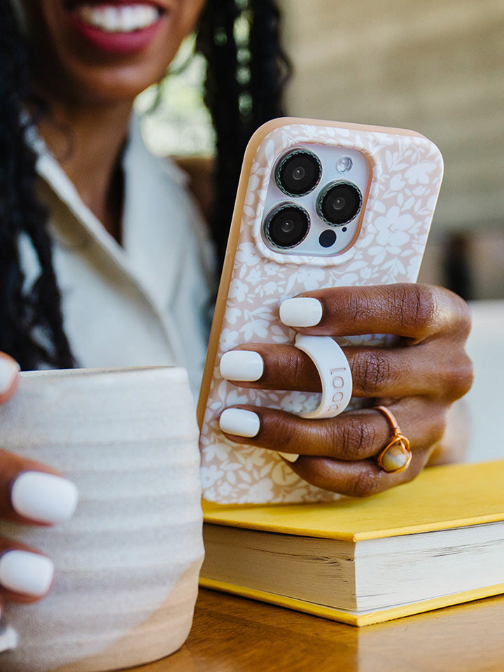  A woman holding a Beige Blossoms Loopy Case.|| feature-media