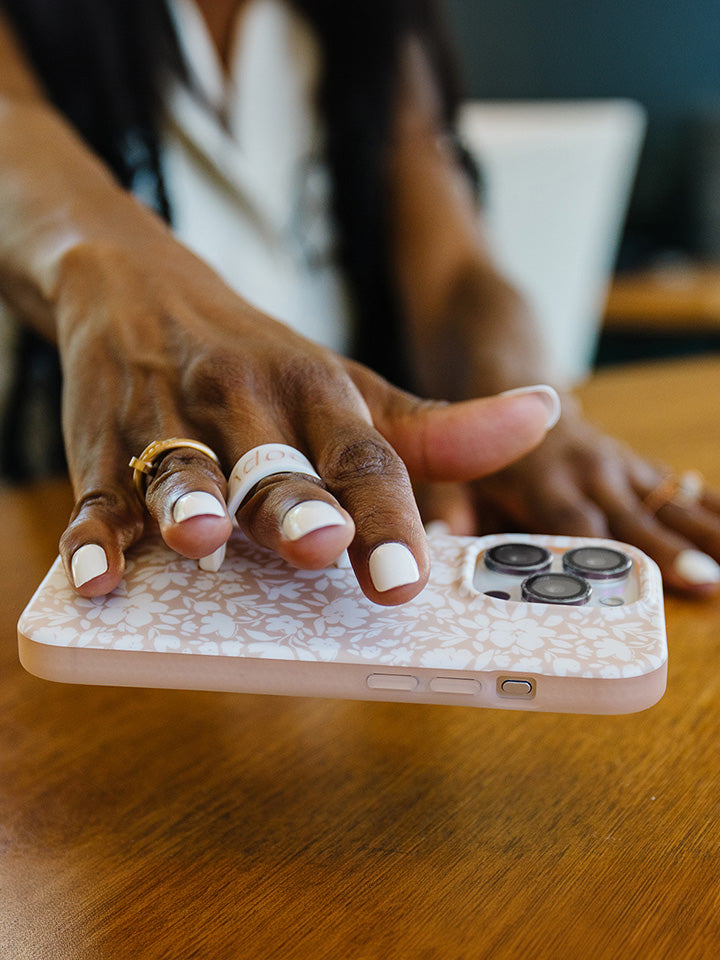  A woman holding a Beige Blossoms Loopy Case.|| feature-media