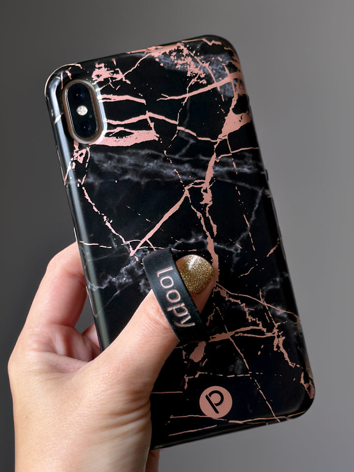 A woman holding a Black Rose Marble Metallic Loopy Case. || feature-media