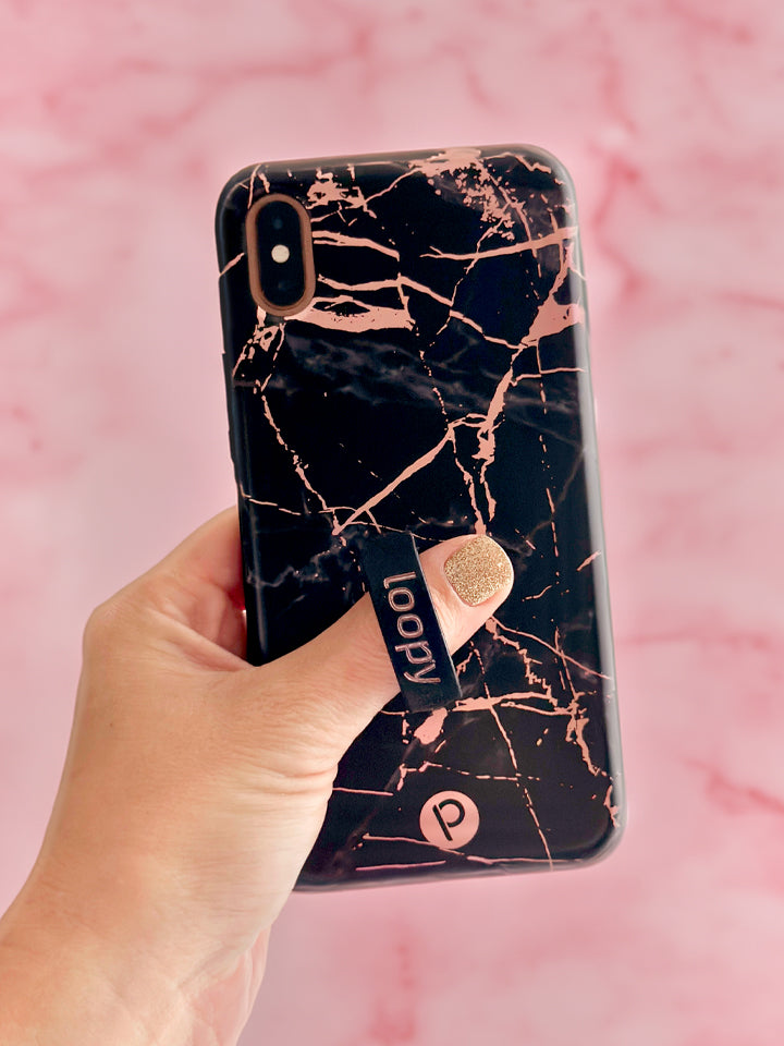 A woman holding a Black Rose Marble Metallic Loopy Case. || feature-media