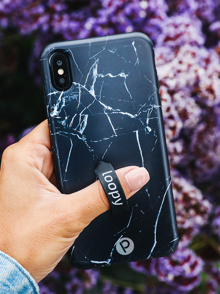 A woman holding a Black Marble Loopy Case.|| feature-media