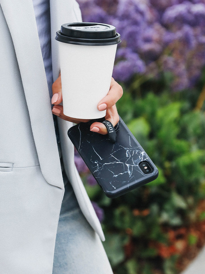 A woman holding a Black Marble Loopy Case.|| feature-media