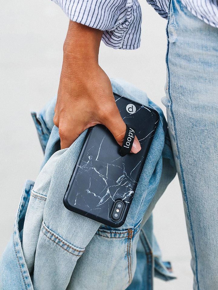 A woman holding a Black Marble Loopy Case.|| feature-media