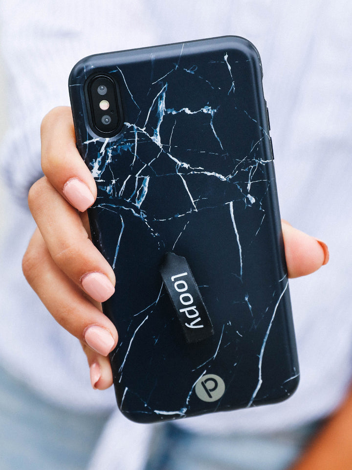 A woman holding a Black Marble Loopy Case.|| feature-media