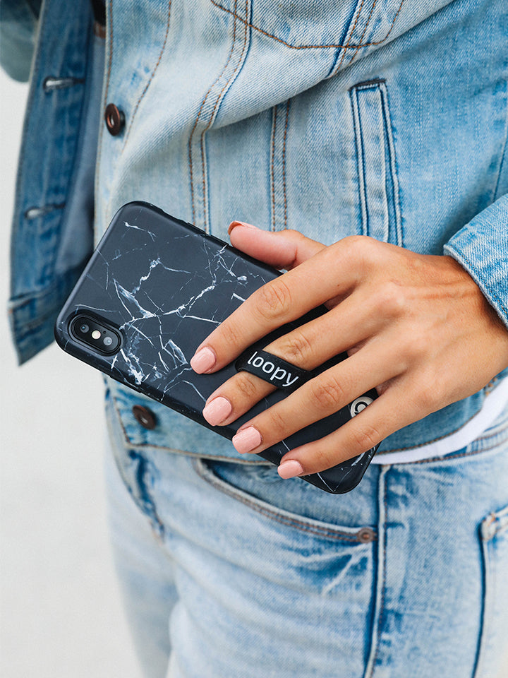 A woman holding a Black Marble Loopy Case.|| feature-media