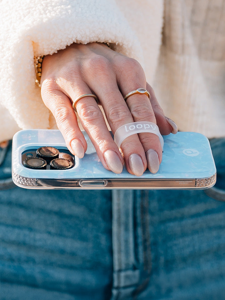 A woman holding a Blue Opal Shell Loopy Case.|| feature-media