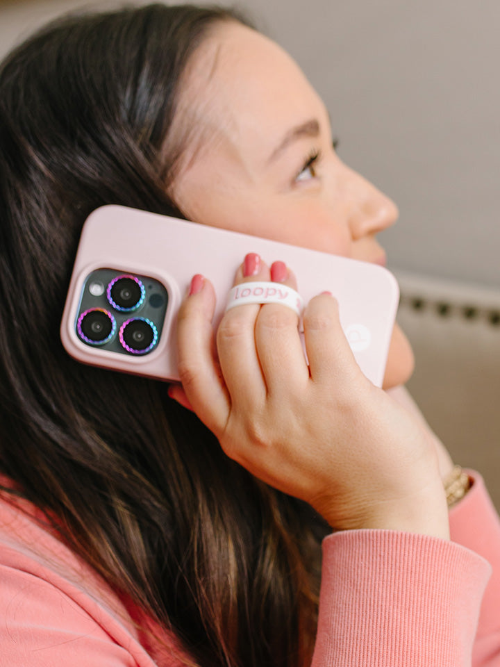 A woman talking on the phone while holding a Blush Loopy Case.|| feature-media