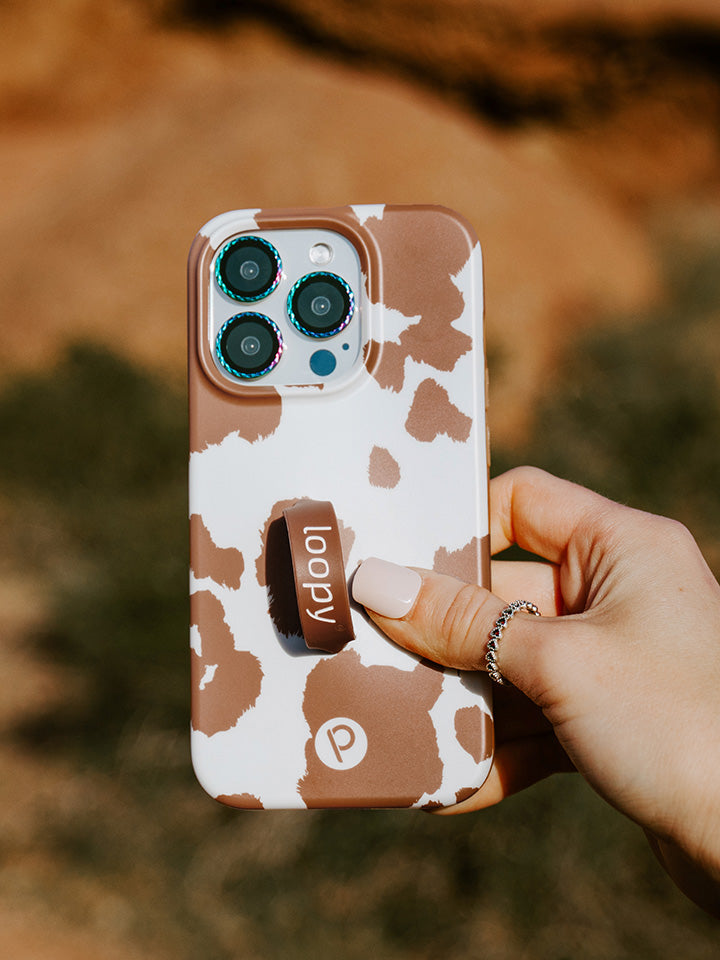 A woman holding a Brown Cow Print Loopy Case.|| feature-media