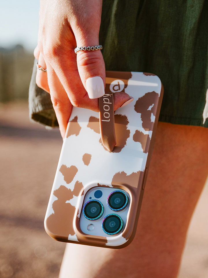 A woman holding a Brown Cow Print Loopy Case.|| feature-media