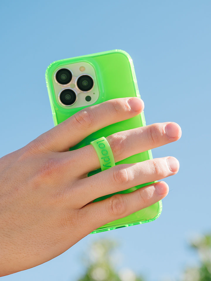 A man holding a Clear Neon Green Loopy Case.|| feature-media