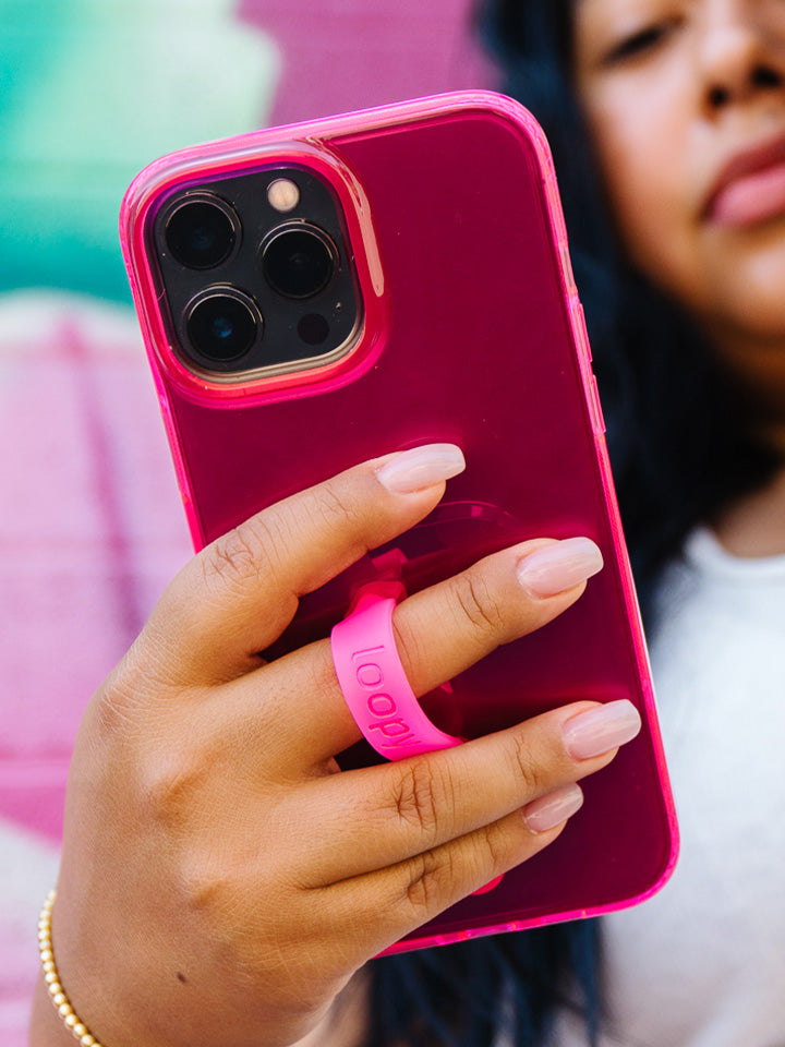 A woman holding a Clear Neon Pink Loopy Case.|| feature-media