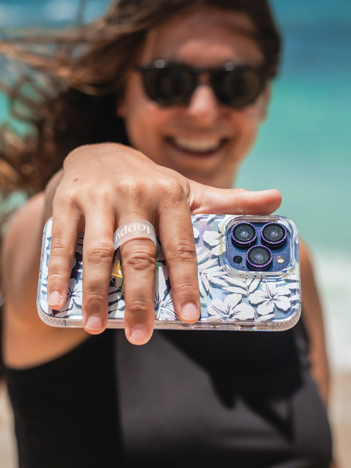 A woman holding a Clear Pearl Paradise Loopy Case. || feature-media