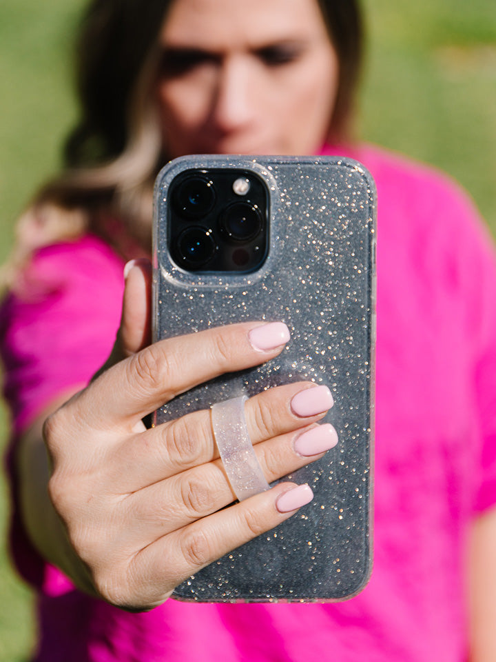 A woman holding a Clear Sparkle Silver Loopy Case. || feature-media