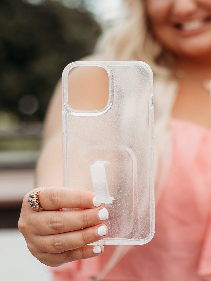  A woman holding a Clear Sparkle Silver Loopy Case.|| feature-media