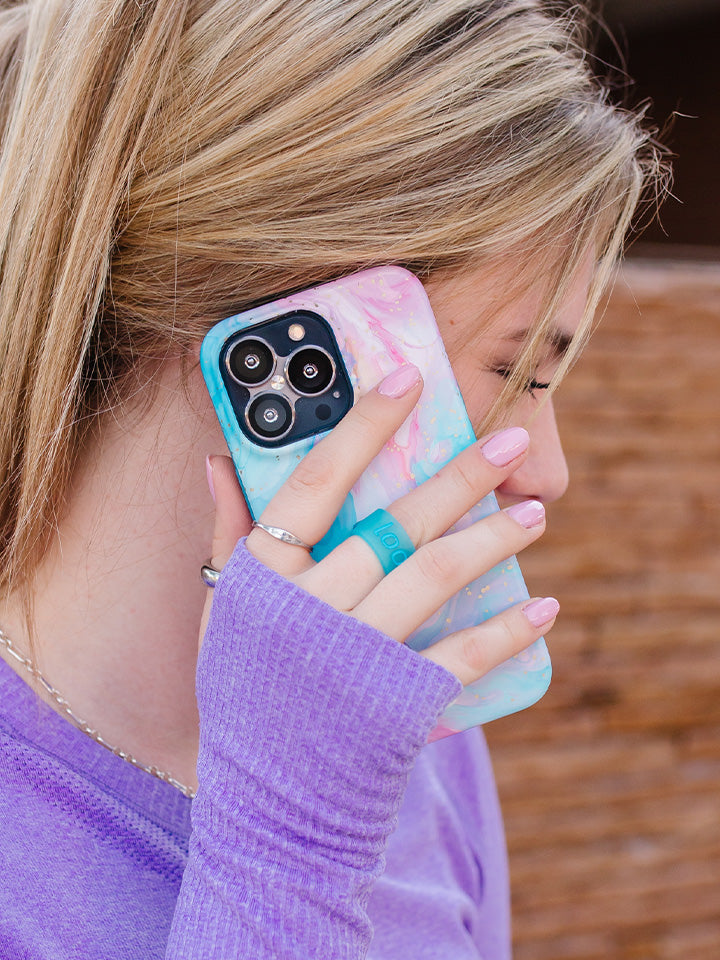 A women talking on the phone while holding a Cotton Candy Swirl Loopy Case. || feature-media