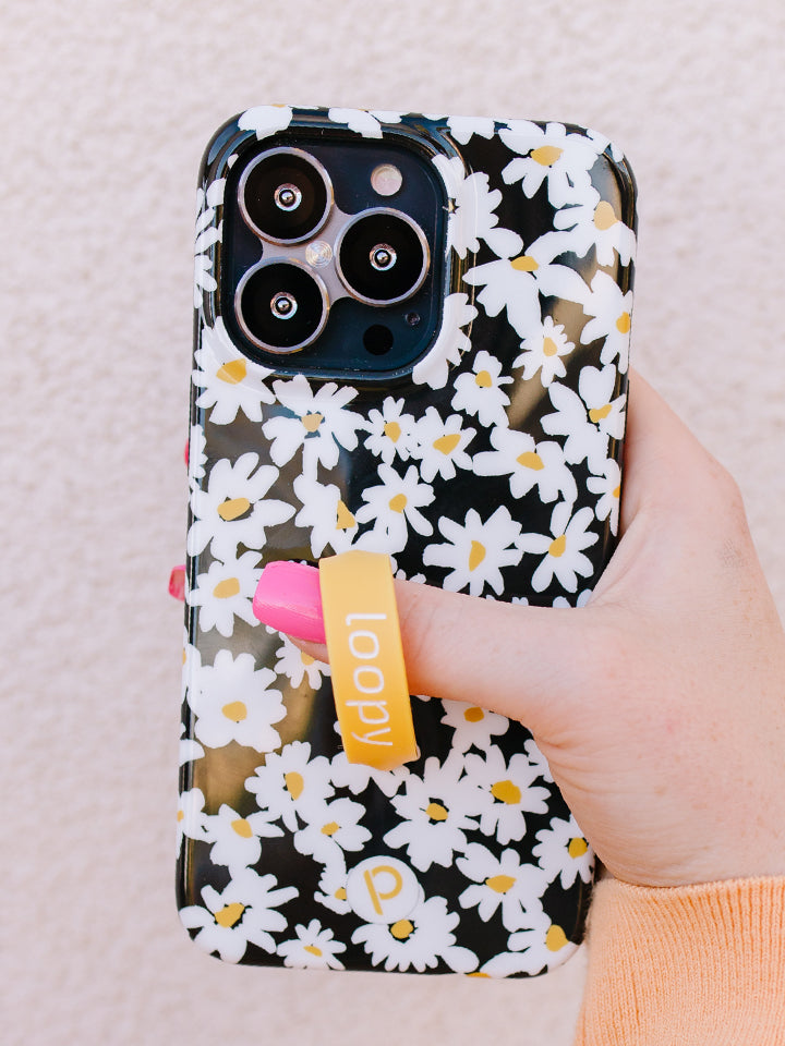 A woman holding a Daisies Loopy Case. || feature-media