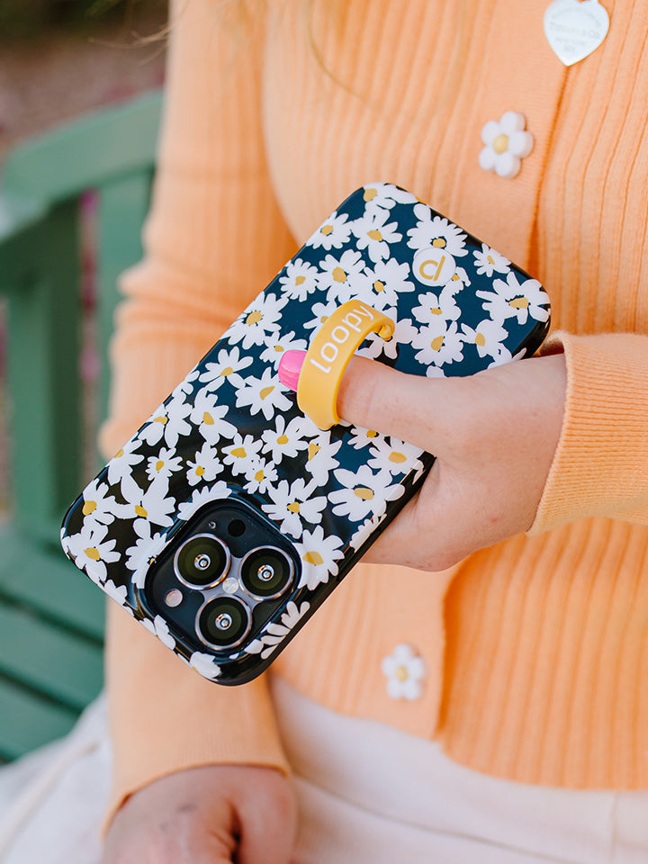 A woman holding a Daisies Loopy Case. || feature-media