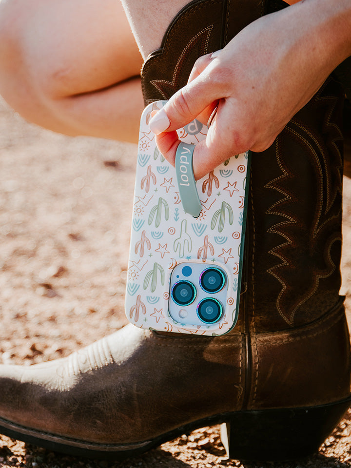 A woman holding a Desert Bliss Loopy Case.|| feature-media