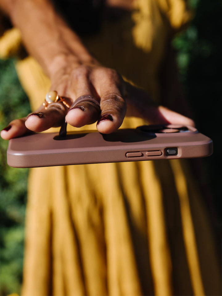  A woman holding an Espresso Loopy Case.|| feature-media