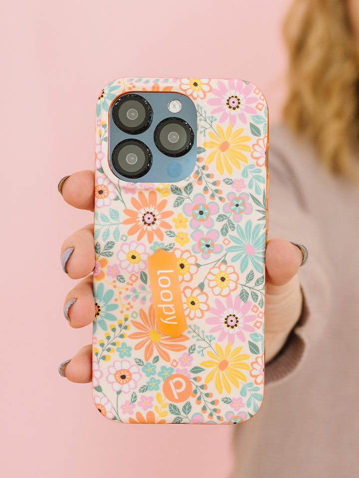 A woman holding a Floral Burst Loopy Case.|| feature-media