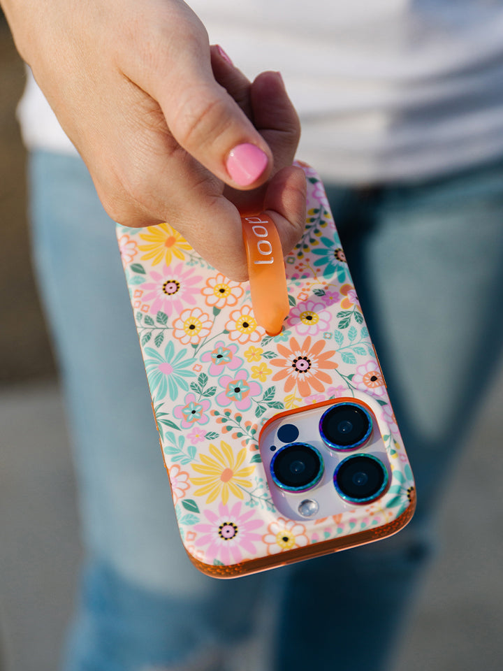 A woman holding a Floral Burst Loopy Case.|| feature-media