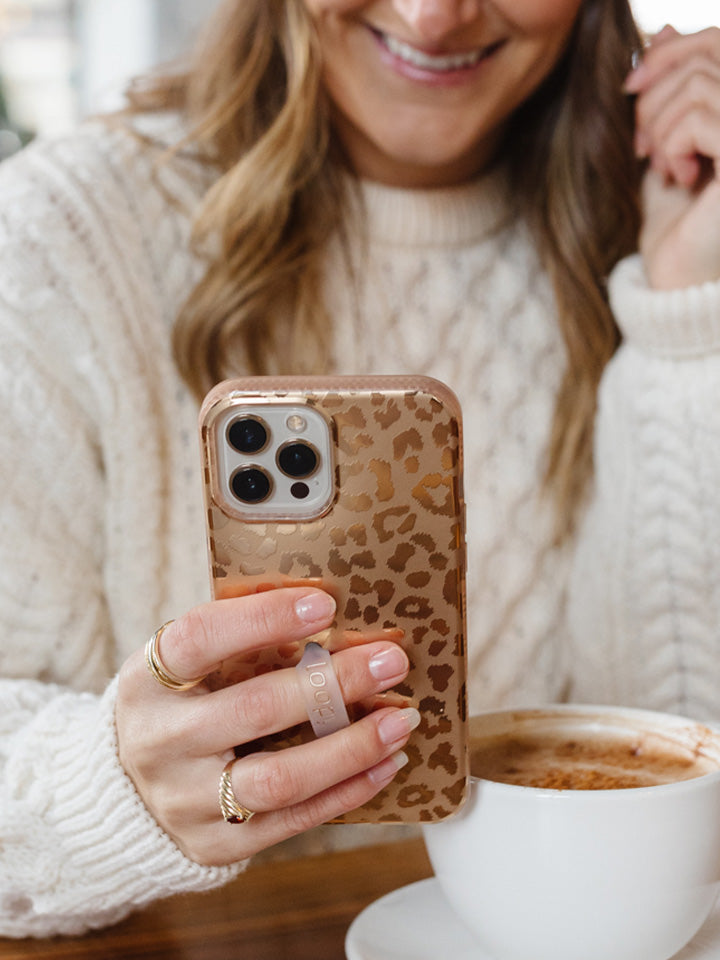 A woman holding a Gold Leopard Loopy Case. || feature-media