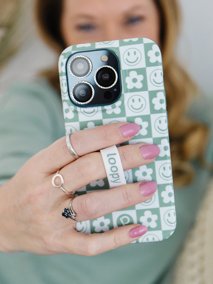 A woman holding a Groovy Sage Checkered Loopy Case. || feature-media