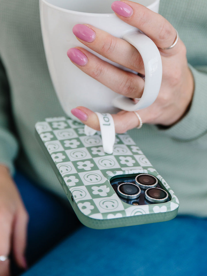 A woman holding a Groovy Sage Checkered Loopy Case. || feature-media