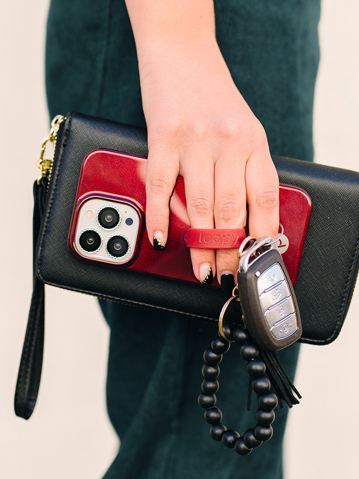 A woman holding a Maroon Shimmer Loopy Case.|| feature-media