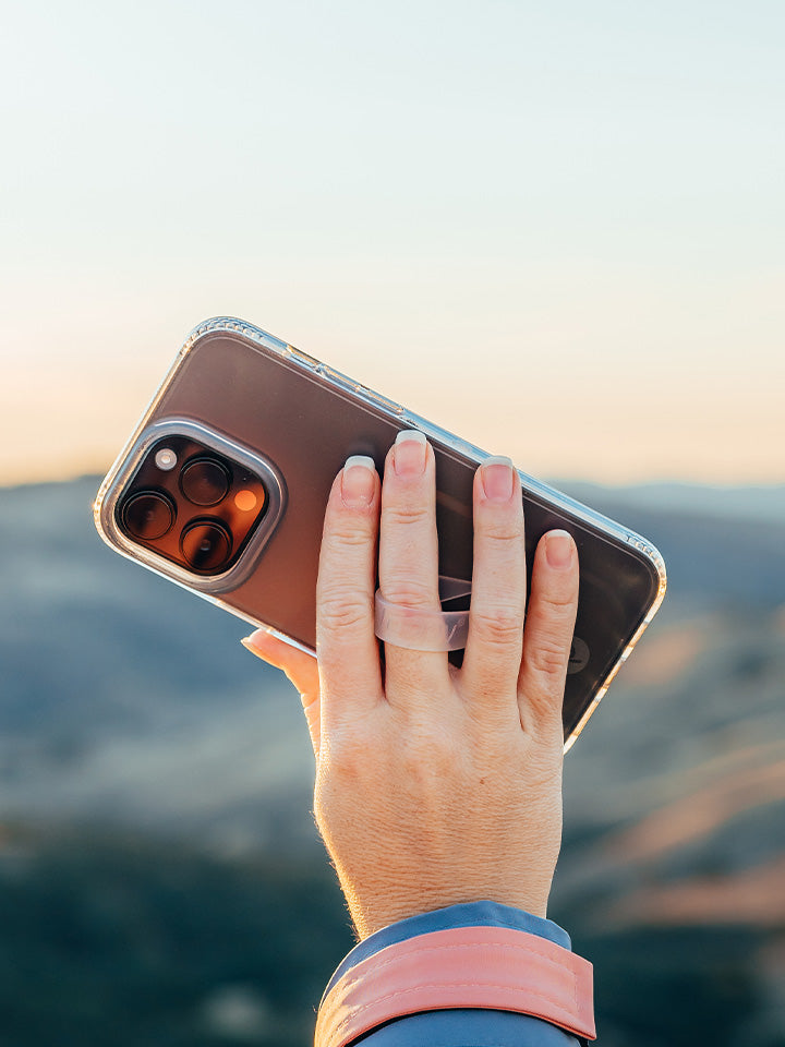 A woman holding a Matte Clear Loopy Case.|| feature-media