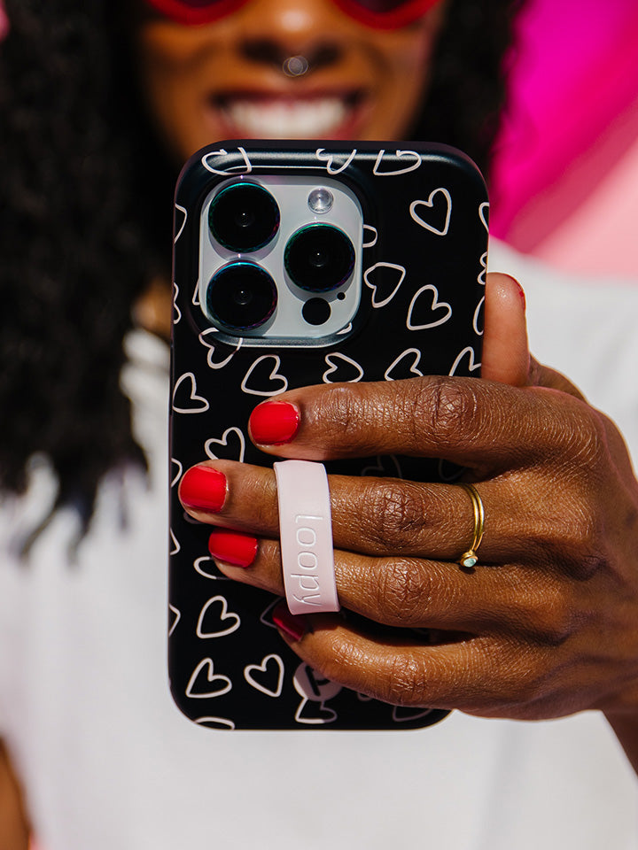 A woman holding a Midnight Hearts Loopy Case. || feature-media