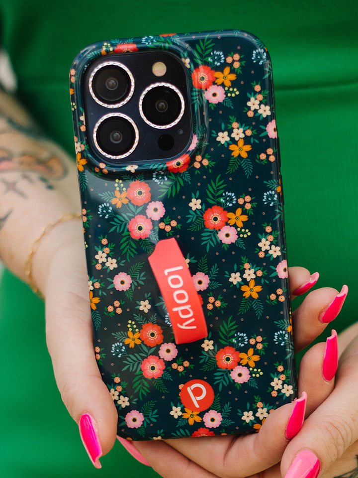 A woman holding a Midnight Meadow Loopy Case. || feature-media