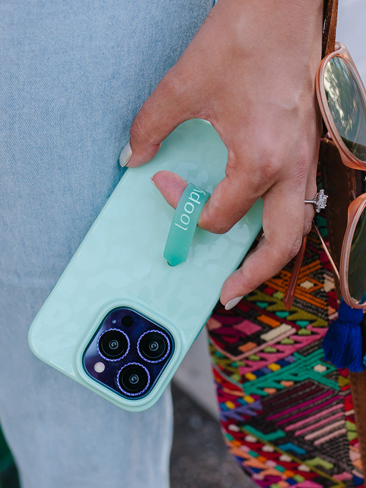 A woman holding a Mint Leopard Loopy Case.|| feature-media