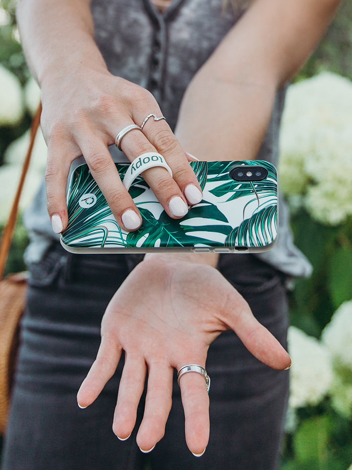 A woman holding a Monstera Loopy Case. || feature-media