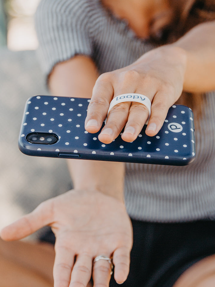 A woman holding a Navy Polka Dot Loopy Case. || feature-media