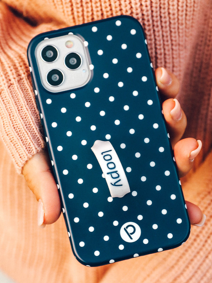 A woman holding a Navy Polka Dot Loopy Case. || feature-media